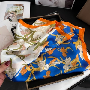 Close-up of blue and orange iris floral silk scarf showing smooth texture and vibrant print