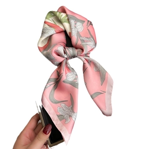 Elegant pink floral silk scarf featuring white lily patterns and a stylish bow design