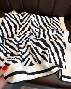 Close-up of zebra print silk scarf showing smooth satin texture and black hemmed edge