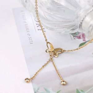 Detailansicht der 18K Roségold Schmetterlings-Fußkette mit funkelnden Zirkonia-Quasten