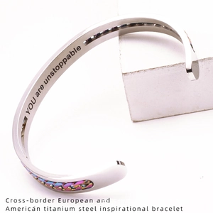 Macro detail of 'YOU are unstoppable' engraving on stainless steel C-shaped cuff bracelet