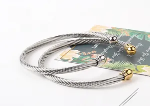 Close-up of twisted cable C-shape bangles in silver and gold-tone finish
