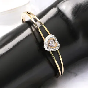 Détail d'un bracelet cœur plaqué or 18k avec design double rangée et oxydes de zirconium