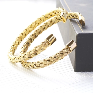 Macro detail of gold-plated twisted cable wire bangle with smooth square end caps