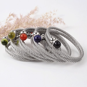 Set di bracciali a cavo intrecciato in acciaio inox con perline colorate su fondo bianco