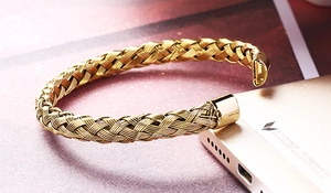Close-up of golden woven wire mesh bangle featuring polished C-shaped metal ends