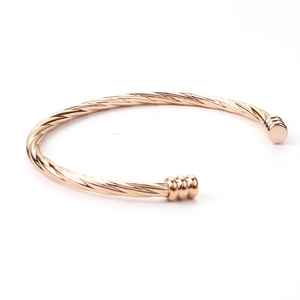 Detail of twisted cable cuff bracelet in rose gold finish with ribbed end caps