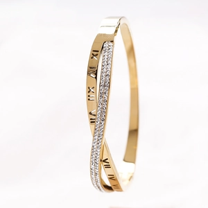 Détail du bracelet doré croisé avec chiffres romains et incrustations de zircons