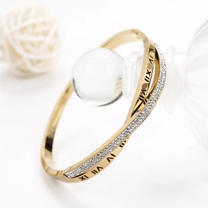 Détail macro du bracelet doré avec gravures de chiffres romains et cristaux micro-pavés