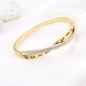 Détail du bracelet croisé en acier doré avec chiffres romains et pavé de zircons