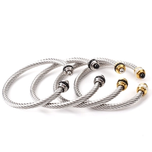 Detail of four twisted cable stainless steel cuff bracelets with diamond-encrusted ball ends