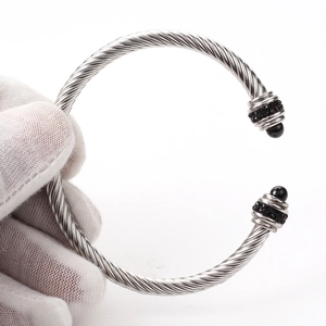 Macro detail of twisted cable stainless steel bracelet with black beads and diamond accents