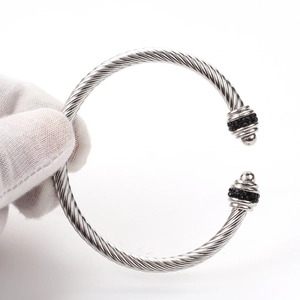 Macro detail of silver twisted cable bracelet featuring black crystal pavé end caps