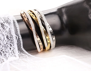 Détail de bracelets gravés de chiffres romains avec incrustation de zircon en or et argent