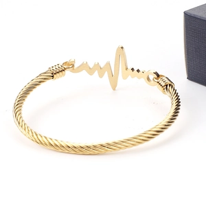 Detail of gold cable twist bangle featuring an elegant heartbeat waveform design