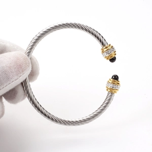 Detail of twisted cable steel bracelet with crystal settings and black bead accents