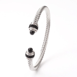 Macro shot of silver twisted cable cuff bracelet with black beads and pavé crystals
