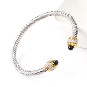 Detail of cable twist steel bangle with gold accents, small crystals and black beads