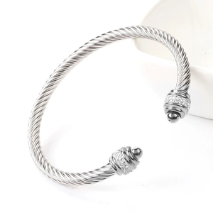 Macro view of twisted cable titanium steel bangle with sparkling pavé set rhinestones