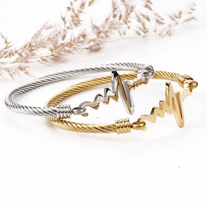 Minimalist 18k gold and silver ECG heartbeat cable wire bangles on white background
