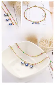 Detail of gold evil eye anklet with colorful beads and small bell charm on white background