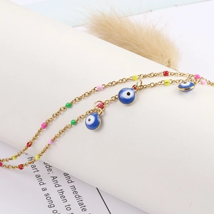 Golden Evil Eye anklet with colorful beads and blue enamel charms on display stand