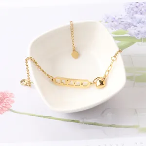 Bracelet cœur LOVE élégant en acier titane doré 18 carats dans un bol en céramique