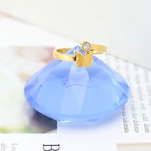 Détail de bague papillon dorée avec zircon sur cristal bleu, gros plan bijoux élégants