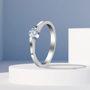 Macro shot of silver ring with white zircon and wavy band on white geometric stand