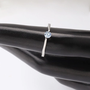 Detail of round brilliant-cut white zircon solitaire ring on thin silver band