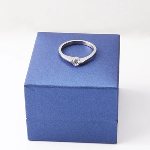 Minimalist silver ring with round white zircon stone on blue textured gift box