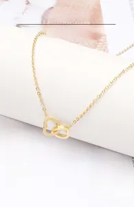 Détail du pendentif cœur évidé en or rose sur une chaîne fine en acier inoxydable