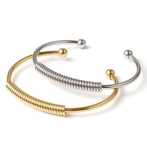 Detail shot of gold and silver spring bracelets with polished spheres and industrial coils