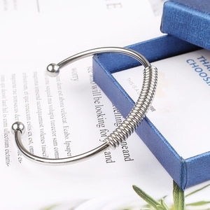 Detail of silver stainless steel spring bracelet with ball ends and spiral wire wrap