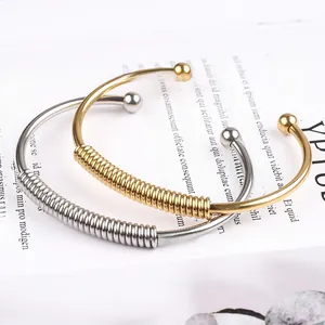 Detail of silver and gold spring-style stainless steel bracelets on decorative card