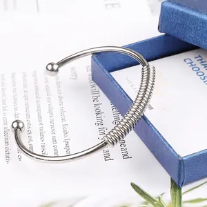 Minimalist silver stainless steel spring bangle featuring a flexible open cuff design