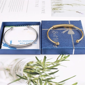 Close-up of gold and silver spring coil bracelets in blue gift boxes with thank you card