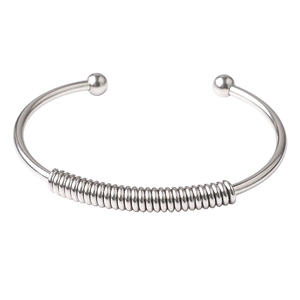 Close-up of silver stainless steel spring cuff bracelet with polished bead ends
