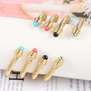 Close-up of 18K gold-plated cable wire open bracelets with colored gemstone end caps
