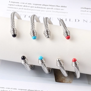Detail of cable twist bracelets with colorful gemstone ends on white product display