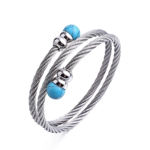 Drelagiges Edelstahl-Kabelarmband mit Türkisperlen auf weißem Hintergrund präsentiert