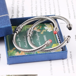 Detail of twisted cable cuff bracelets in silver finish with colorful bead end caps