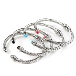 Detailed macro view of four silver twisted wire bangles with colorful stone end caps