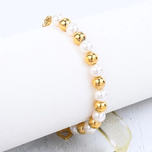 Elegant pearl and gold bead bracelet with a heart charm and lobster clasp closure