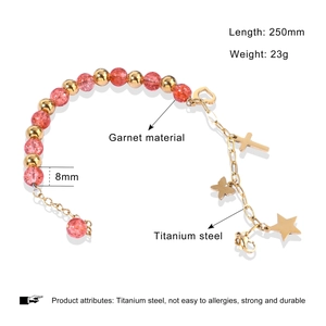 Detail of titanium steel beaded bracelet with pink garnets and gold charms