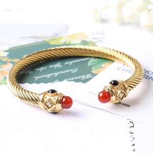 Dettaglio macro del bracciale a cavo dorato con onice finto e accenti di cristallo