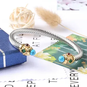 Dettaglio del bracciale rigido a cavo intrecciato con gemme colorate e punte dorate