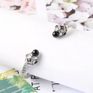 Dettaglio del bracciale rigido a cavo intrecciato argento con pietre nere e gemme