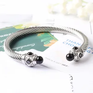 Dettaglio macro del bracciale rigido a cavo ritorto con pietre nere incastonate