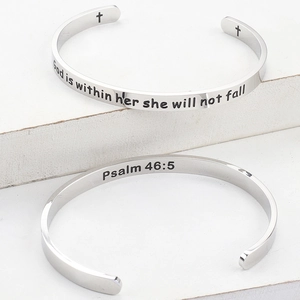 Detailed macro of polished stainless steel cuff with God is within her she will not fall text